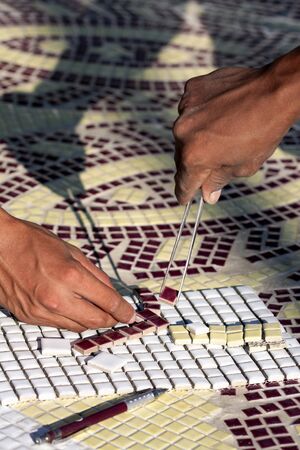 Worker tongs mosaic tiles for decorの写真素材