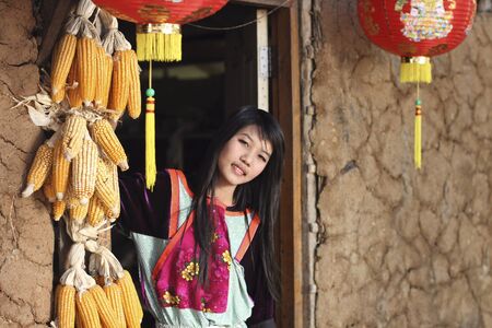 MAEHONGSON, THAILAND - FEB 11 :  Earthen House village, Lisu Hill tribe girl in traditional costume at door of earthen house on Feb 11, 2011 in Maehongson, Thailand.のeditorial素材