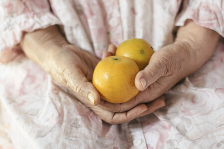 Chinese orange in old woman handsの写真素材