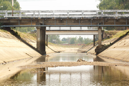 Low water level in irrigation canal on summerの写真素材