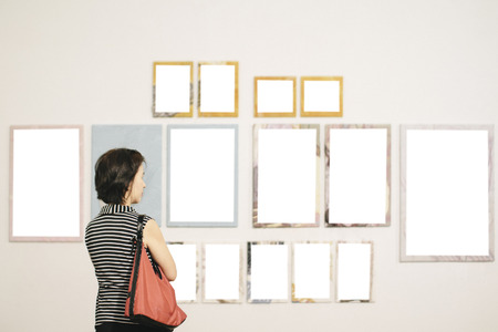 Asian woman standing in an art gallery in front of frame の写真素材