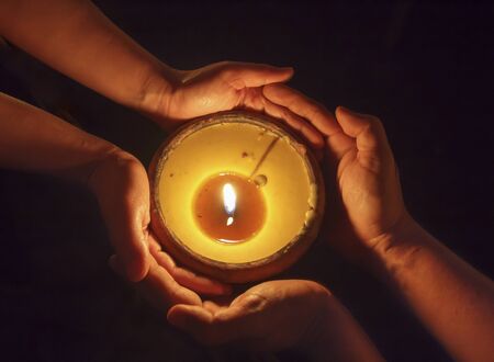 Candle in the hands togetherの写真素材