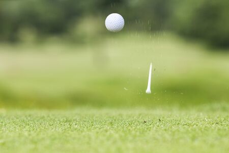 Golf ball just coming off the tee after hit by driverの写真素材