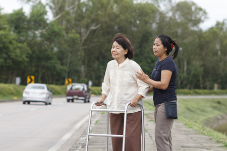 senior woman using a walker cross streetの写真素材