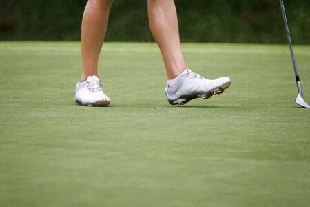 Female golfers walking on green .の写真素材