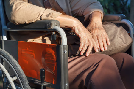 Elderly hands on a wheelchair.の写真素材