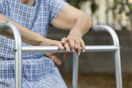 Elderly sitting in backyard with walker.の写真素材