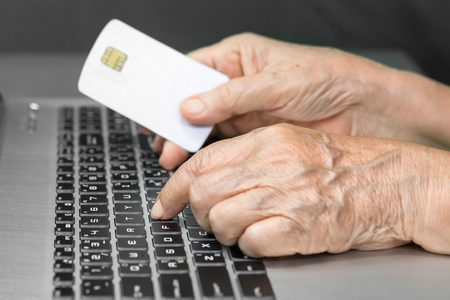Elderly person using credit card for online shoppingの写真素材