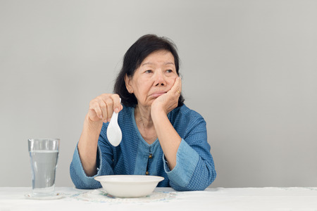 Elderly asian woman bored with foodの写真素材