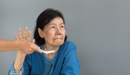 Elderly asian woman bored with foodの写真素材