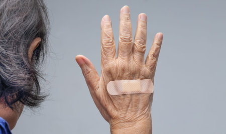 Elderly woman adhesive bandage on her handの写真素材