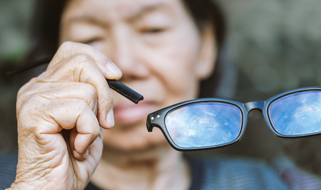 Elderly asian woman repair broken glassesの写真素材