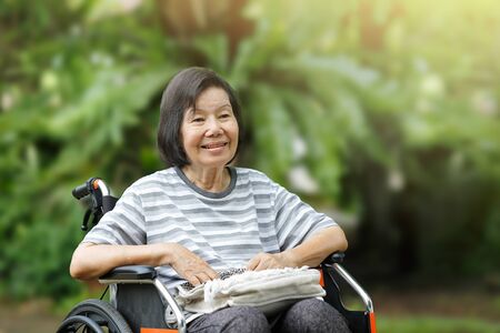 smiling elderly woman ,sitting on wheelchairの写真素材