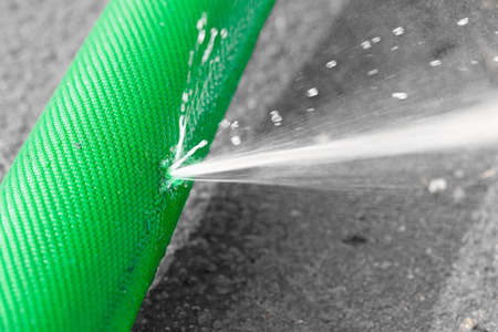 water leaking from hole in a hoseの写真素材