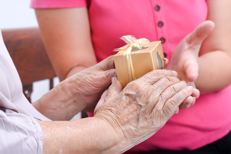 Elderly woman receiving a gift from daughterの写真素材