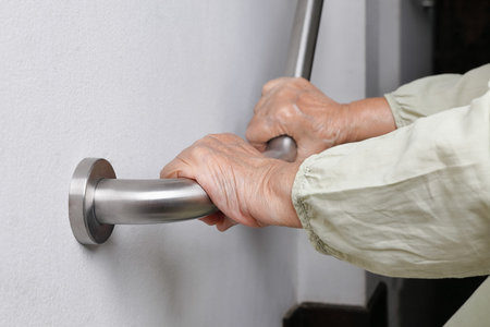Elderly woman holding on handrail for safety walk steps
