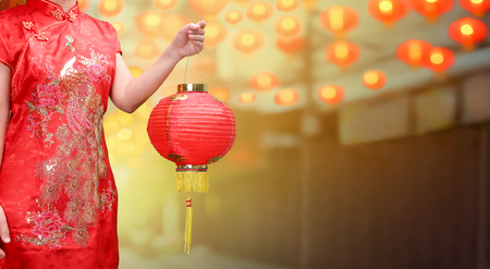 woman holding chinese new year lanterns in china townの写真素材