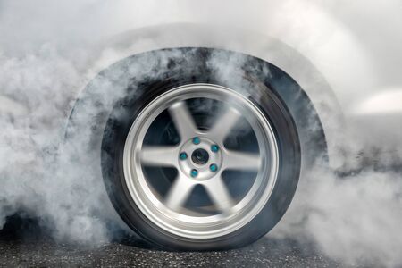 Drag racing car burns rubber off its tires in preparation for the raceの写真素材