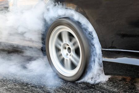 Drag racing car burns rubber off its tires in preparation for the raceの写真素材