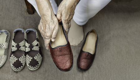 Elderly woman putting on shoesの写真素材