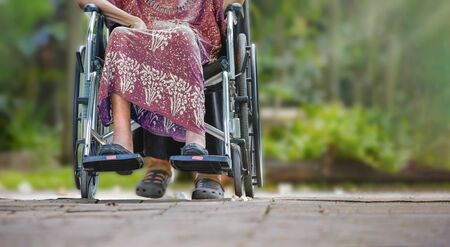 Elderly woman on wheelchair at home with daughter take careの写真素材