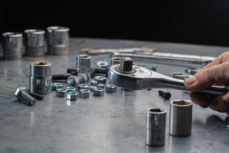 Close up automotive mechanic picking tools in garageの写真素材