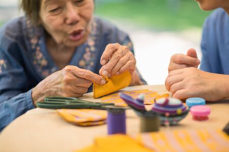 Elderly woman with caregiver in the needle crafts occupational therapy  for Alzheimerâs or dementiaの写真素材