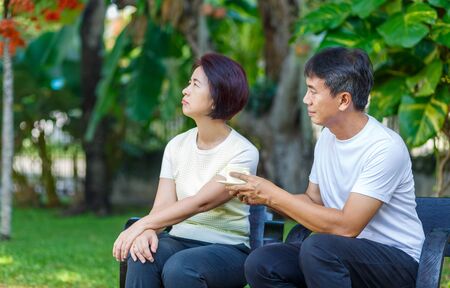 Asian middle aged male asking to make up with his wifeの写真素材