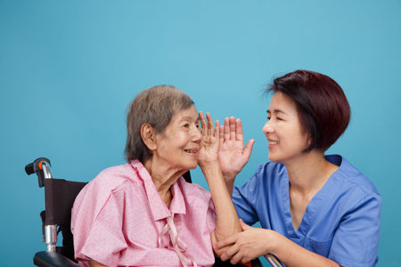 Caregiver take care asian elderly woman while using dental fross stick.