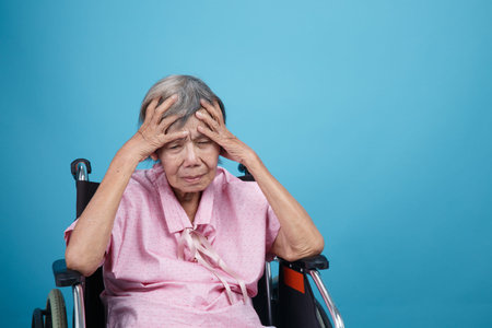 Caregiver take care asian elderly woman while using dental fross stick.