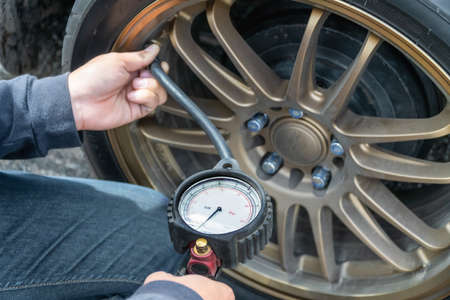 Tire Pressure Gauge and technician hands checking tyre pressureの写真素材