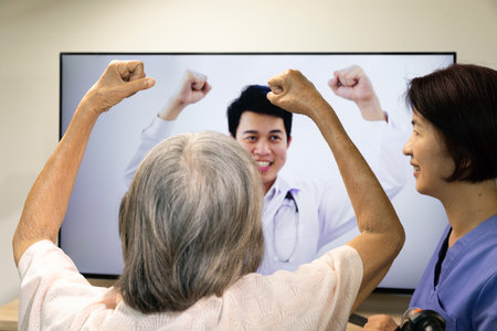 Elderly woman using physical therapy online service at home.の写真素材