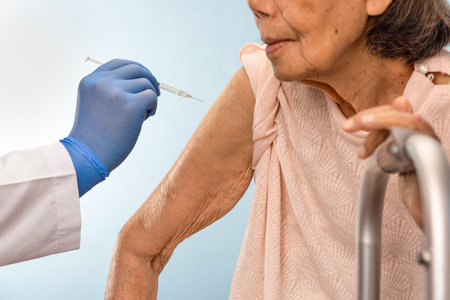 Doctor doing vaccine injection to senior woman.の写真素材