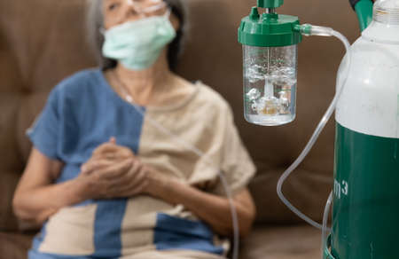 Elderly woman wearing oxygen nasal canula at home.の写真素材