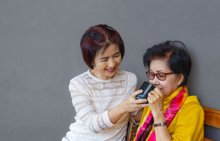 Asian middle aged daugther takecare senior mother at homeの写真素材
