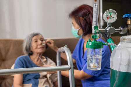 Elderly woman wearing oxygen nasal cannula at home.の写真素材