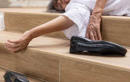 Elderly woman falling down on stairの写真素材