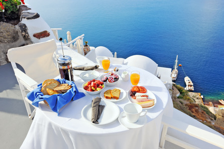 Breakfast on a terrace overlooking the sea in Oia, Santorini, Cyclades, Greeceの写真素材