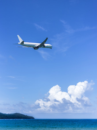 plane fly over the blue sea の写真素材