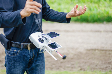 huge white remote control of drone for agriculture hanging on a man neck standing in front of the...