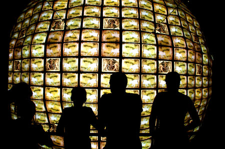people standing in front of a television cube