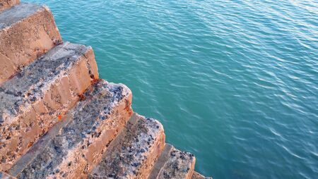 Concrete stairway old fishing port's and sea water background.の写真素材