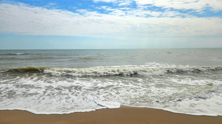 The ocean wave on high tide day in rain season with cloudy sky beach landscape.の写真素材