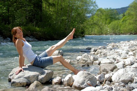 A woman enjoys the cooling on a cold River.の写真素材