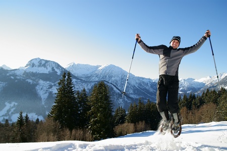A man makes a snowshoe tour in a beautiful mountain landscape.の写真素材
