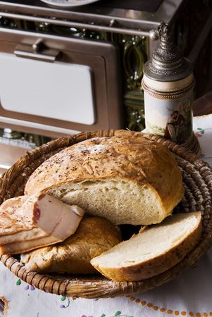Homemade bread and bacon, vintage beer stein and stove in the backgroundの写真素材