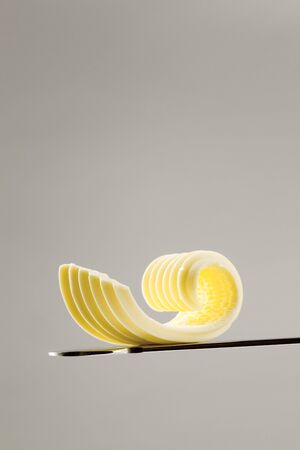 Closeup of a butter curl on a knifeの写真素材