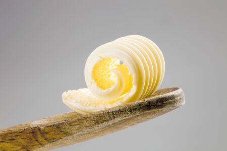 Closeup of a butter curl on a wooden spoon の写真素材