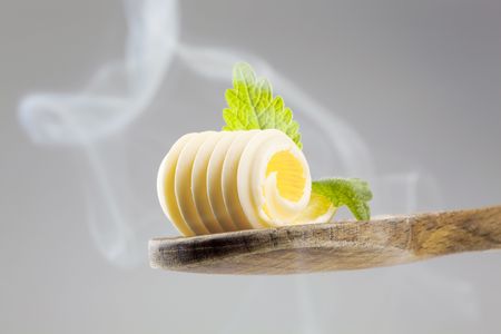 Butter curl on a wooden spoon in steamの写真素材