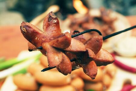 Roasted sausages on a metal forkの写真素材